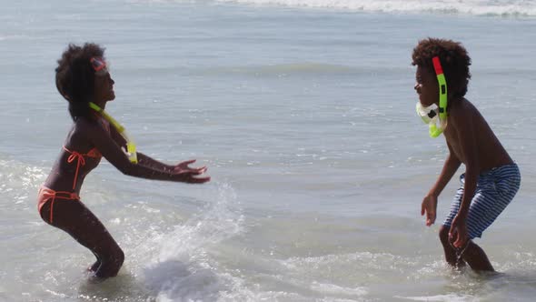 African american children wearing scuba goggles playing at the beach