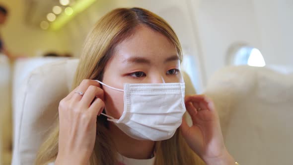 Traveler Wearing Face Mask While Traveling on Commercial Airplane