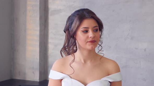 A Girl in a White Dress Poses for a Photographer and Steps Out of the Frame