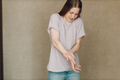 Young woman with hand convulsions pain ache against brown background. - PhotoDune Item for Sale