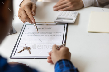 ting insurance terms detail to customer while pointing with a pen where the policyholder must to sign. Signing agreements for house purchases, leases and mortgages.