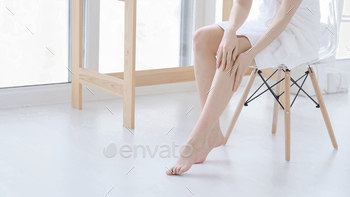 s, enjoy beauty procedures. young asian woman applying cream and lotion touch foot dry on bed. Copy space.