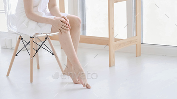 s, enjoy beauty procedures. young asian woman applying cream and lotion touch foot dry on bed. Copy space.