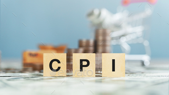 a wooden block with the word CPI and cart, dollar bills, dollar coins. on blurred background