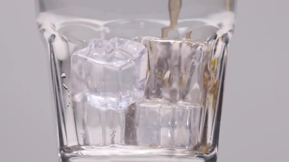 Pouring Whiskey Into The Glass with Ice