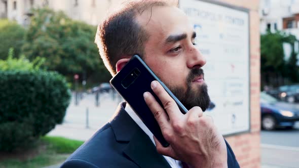 Caucasian Man in Business Suit on the Phone Outdoor in the City