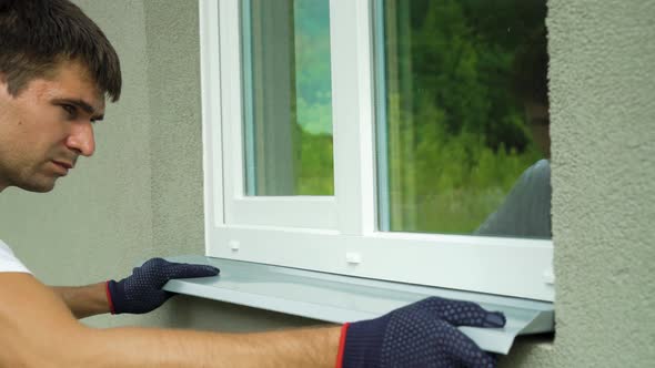 Man Worker in Protective Gloves Measuring External Frame and PVC Window Metal Sill Size