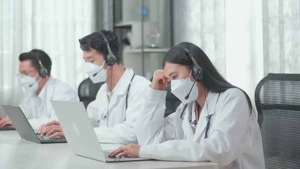 A Woman Of Three Asian Doctors In Masks Working As Call Centre Agent Headache While Work