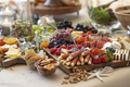 Elaborate charcuterie table set up with meats, bread, cheese, nuts, and fruit. - PhotoDune Item for Sale