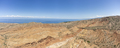 Wide panorama of the desert of Skazka Canyon with lake Issyk-Kul in the background. - PhotoDune Item for Sale