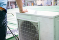 Condensing unit of an air conditioner on blur technician spraying water. Air conditioner cleaning  - PhotoDune Item for Sale