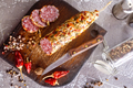 Salami sausage with slices on wooden board on a table - PhotoDune Item for Sale