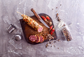 Salami sausage with slices on wooden board on a table - PhotoDune Item for Sale