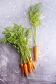 Bunch of fresh carrots with green leaves over wooden background. - PhotoDune Item for Sale