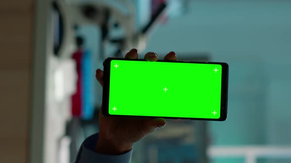 Vertical Video Close Up of Chemist's Hand Holding Phone with Green Screen