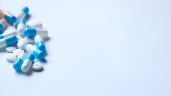 White and Blue Capsule Spilling on White Background 