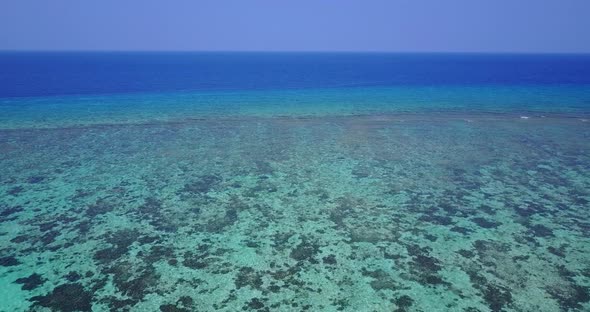 Wide angle overhead island view of a white sandy paradise beach and blue water background in best quality