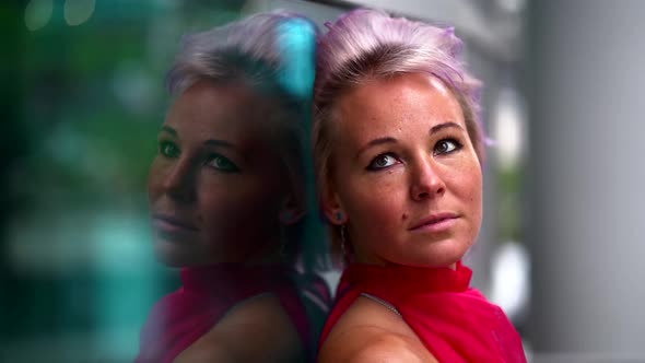 Portrait of Middle-aged Woman with Pink Hair in City, Reflection of Her in Mirror Wall