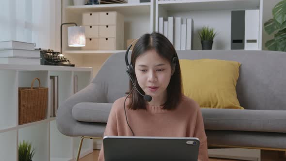 Woman in casual clothes and wearing microphone headset of customer support phone operator.