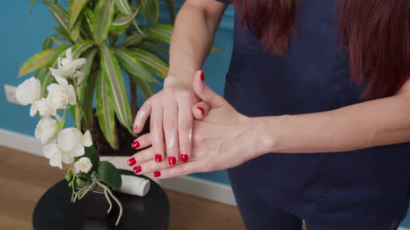 Woman Applying Lotion on Hand Moisturizing Skin with Daily Cream