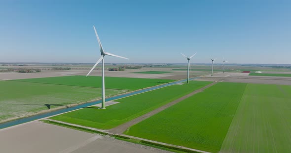 Wind turbines spinning and generating clean energy in Holland, with classic water canal