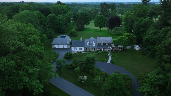 Pull back reveal - Aerial view of large family home. Overcast skies in early morning. Quiet property