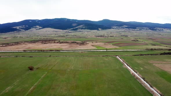 Olt river in Romania and Harghita Mountains in background. Aerial rising