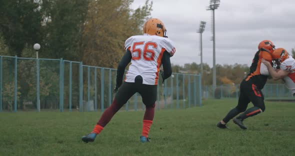 American Football, Football Players in the Game, the Player Catches the Ball and Falls To the Ground