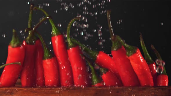 Super Slow Motion on Pods of Red Chilli Pepper in a Row Drops Water