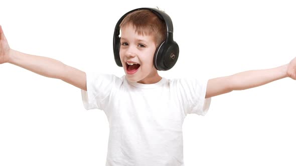 Happy Caucasian Elementaryschool Aged Boy Listening Music Through Black Big Headphones and Waving