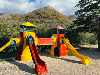 Colorful game set with three slides against the backdrop of green mountains