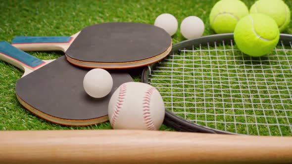 Sport Equipment Rackets and Balls on Grass Background