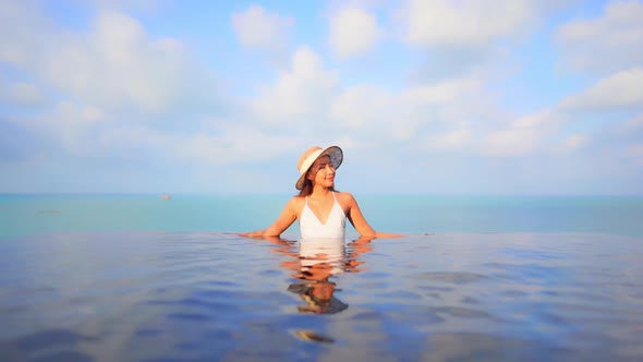 Young asian woman enjoy around outdoor swimming pool for leisure