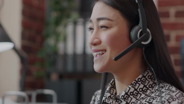 Close Up of Call Center Employee with Headphones Talking on Phone Call