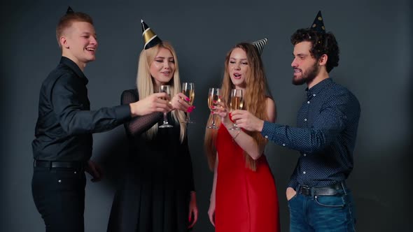 Four Beautiful and Cheerful Friends Are Clinking Glasses with Champagne