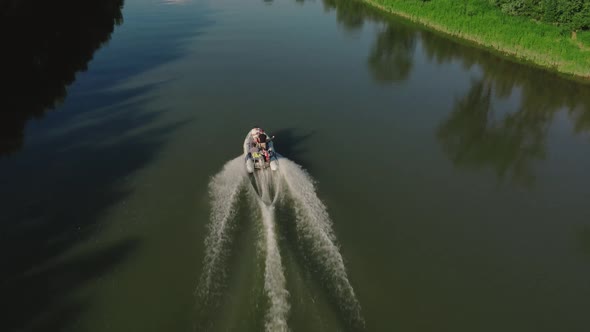 A small motorboat driving through a small cut surrounded by beautiful scenery in the middle of a den