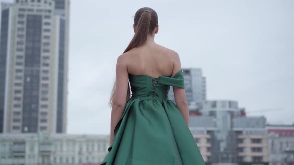Back View of Beautiful Gorgeous Girl in a Stunning Evening Green Dress Walking Fascinatingly