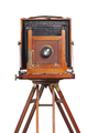 Antique bellows style camera front view close up on an old tripod isolated on white - PhotoDune Item for Sale