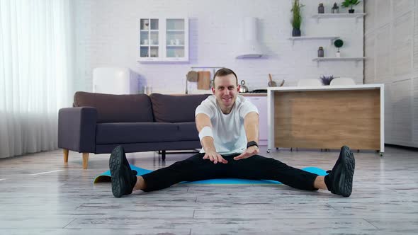 Sport exercises at home. A man does a warm-up before starting to exercise