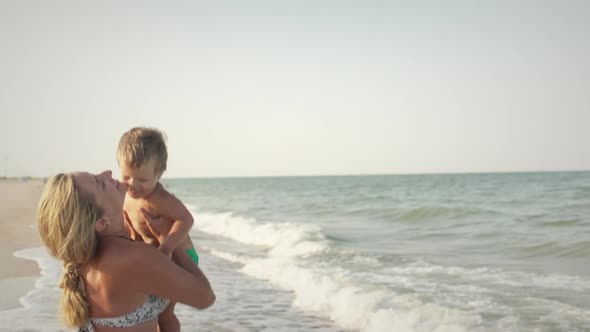 Mom Throws Her Son Up Over the Sea on Summer Vacation Under the Warm Sun