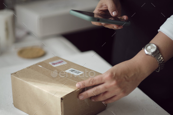  delivery through the application on a smartphone. online store seller entrepreneur packing package post shipping box preparing delivery parcel