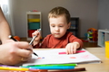 A cute little toddler boy of two years old with dad draws with markers in the album  - PhotoDune Item for Sale