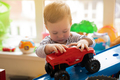 Toddler boy plays with car toys in the children's room. E - PhotoDune Item for Sale