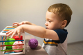A cute toddler boy is playing a game with sensory colorful balls - PhotoDune Item for Sale