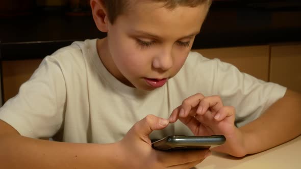 Cute Boy 67 Years Old Playing the Application on the Mobile Phone