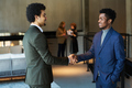 Side view of two young male business partners shaking hands - PhotoDune Item for Sale