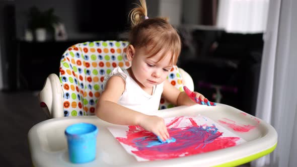 Cute Little Girl Painting with Fingers at Home