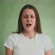 Stressed Woman Cries and Bites Lips on Green Background - VideoHive Item for Sale