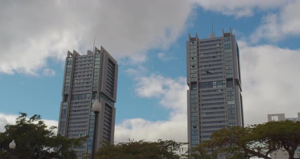 Time Lapse. High Twin Buildings. Clouds in the Sky in Sunny Day