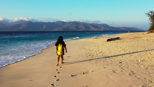 Lady alone tans on marine tourist beach holiday by blue green water with white sandy background of t